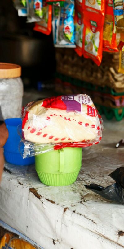 A local market stall in Abuja displaying various packaged goods on a counter.
