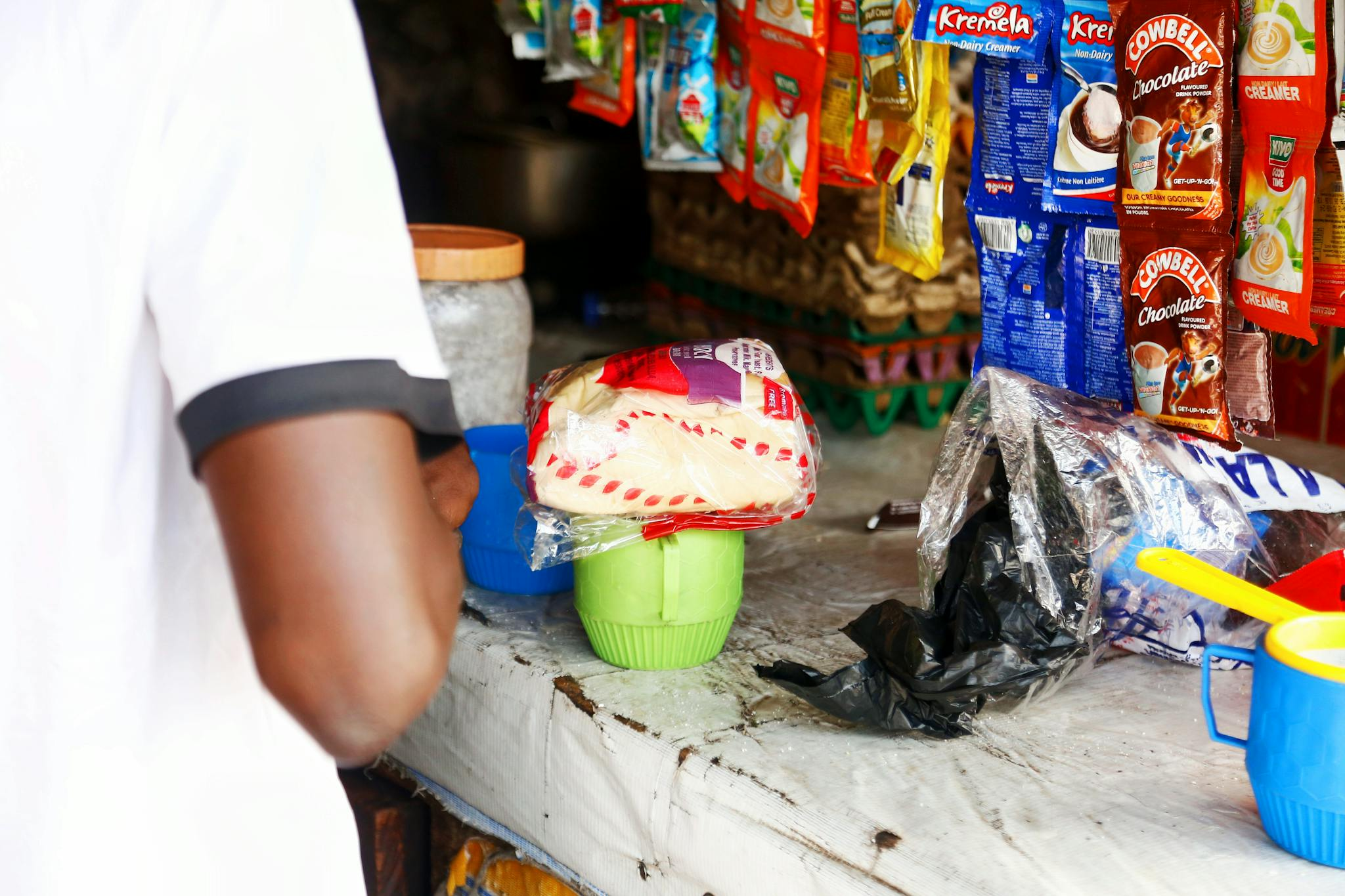 A local market stall in Abuja displaying various packaged goods on a counter.